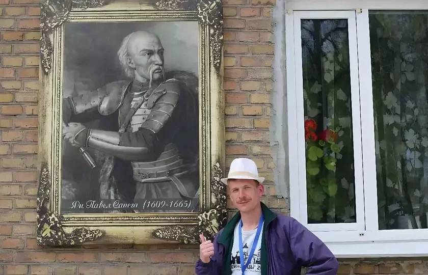 Антон Арцюх на фоне портрета Льва Сапеги и кирпичной стены